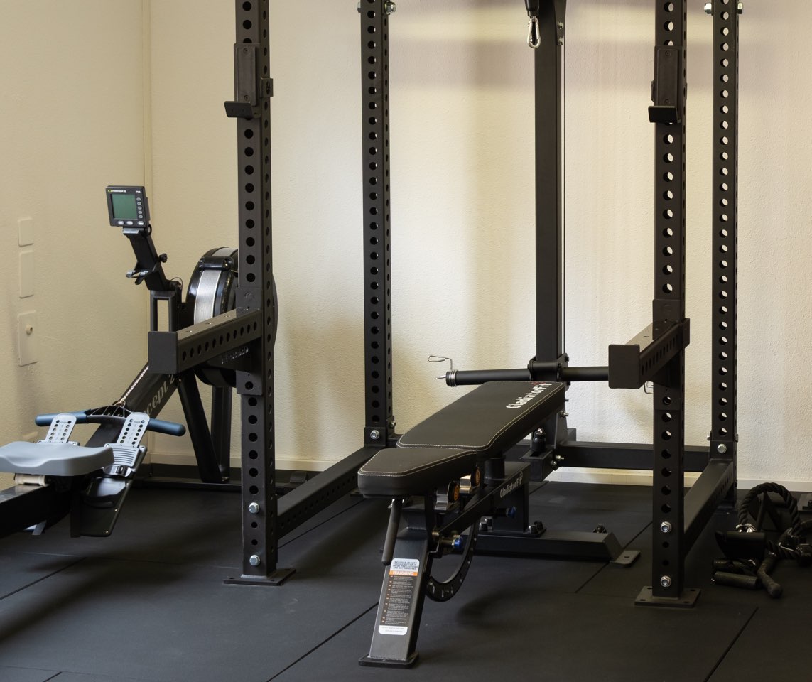 Rameur, cage et banc de musculation dans la salle d’entraînement
