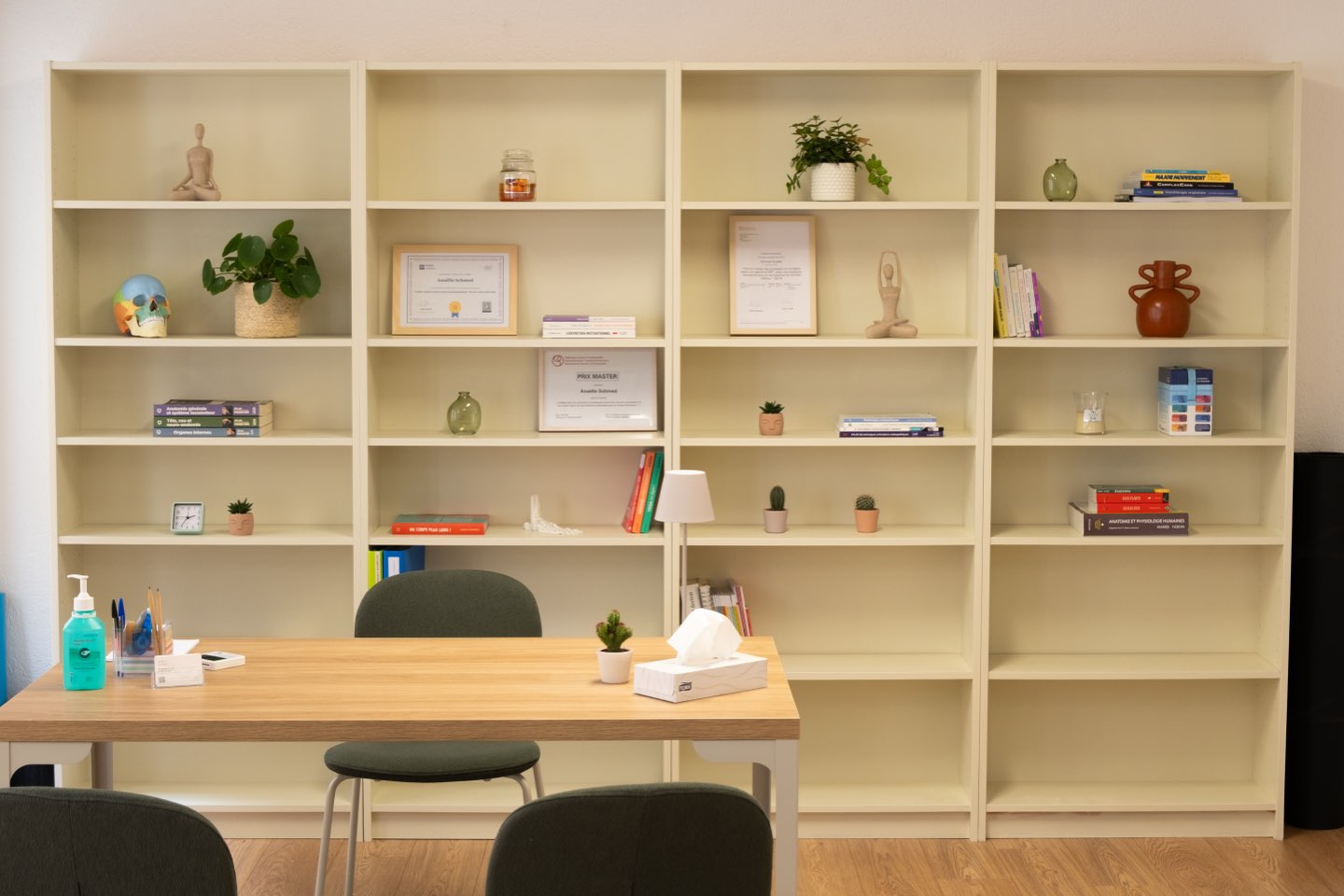 Un bureau de consultation devant une bibliothèque garnie de livres et de diplômes